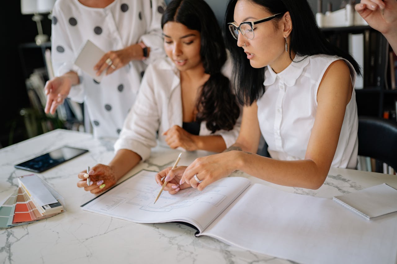 Crafting Captivating Headlines: Your awesome post title goes here Professional women discussing project details during a collaborative office meeting.